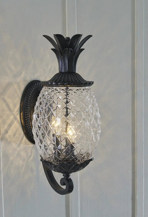 Three Light Outdoor Wall Mount Sconce In Matte Black With Pineapple Cut Glass, mounted on wall, lit with bulbs, traditional design.