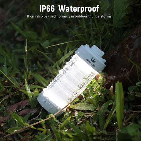 Rechargeable Camping Lantern With RGB Light 550LM Brightness Waterproof Tent Light lying on wet grass