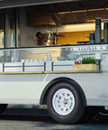 Food truck with open serving window, stainless steel kitchen, and trailer tire and wheel set with ST175/80D13 tire on 13 inch rims