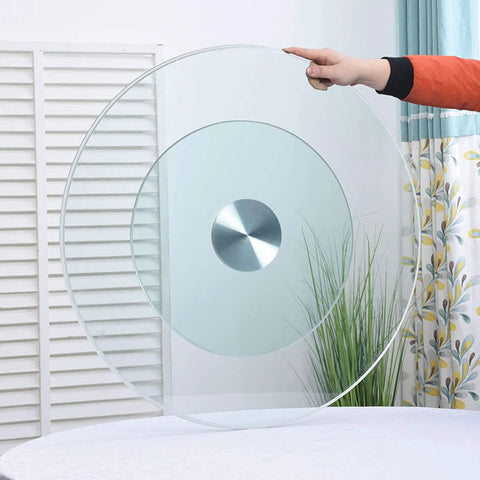 Hand holding Heavy Duty Round Tempered Glass Turntable 24 To 33 Inch Lazy Susan for kitchen tabletop display.