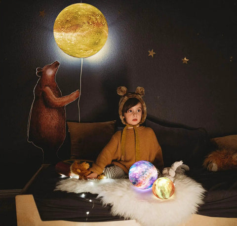 Child in cozy bedroom with Moon Lamp Galaxy Night Light 3D Printed LED Moon Light With Stand 16 Color Options Remote And Touch Control USB
