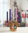 Purple, pink, and white candles in decorative holder with nativity scene in festive home setting.