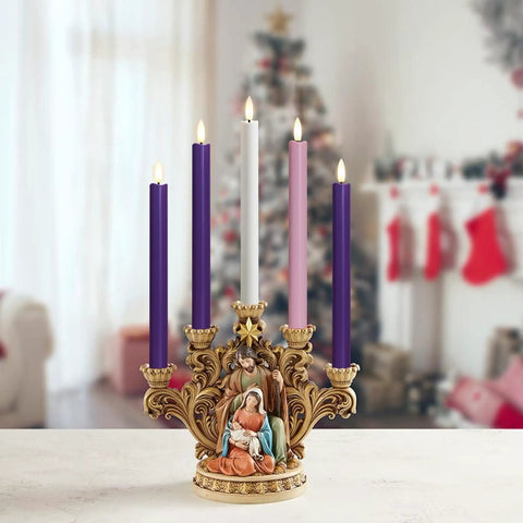 Purple, pink, and white candles in decorative holder with nativity scene in festive home setting.