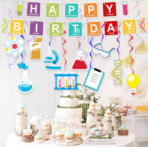 Periodic Table Birthday Banner And Chemistry Theme Backdrop For Science Classroom Party Decor Dope Durable Reusable Fabric Lab Theme Decorations Includes One Happy Birthday Banner And Ten Hanging Swirls For Boys And Girls featuring colorful periodic table and science icons over a dessert table.