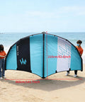 Large blue and black inflatable surf wing for kitesurfing, measuring 360x210cm, held by two people on a beach