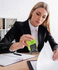 Reliable Self Inking Date Stamp With Rock Solid Green Body And Two Black Refill Pads For Hustling Offices And Home Desks in use on paperwork.