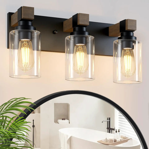 Give Your Mirror Space A Major Glow Up With This Three Bulb Bathroom Vanity Light In Matte Black And Raw Wood Grain Secured By Rock Solid Steel Mounts For Straight Up Rustic Charm, showing clear glass bulbs.