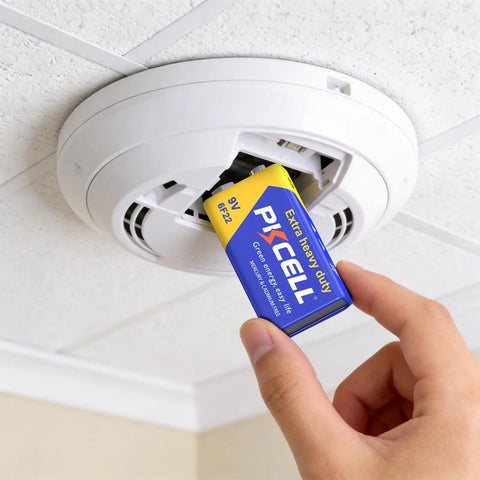 Person installing a Heavy Duty 9V Battery in a smoke detector for secure home safety gear.