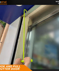 Person using hook to pull down a shutter door with Lieweshal hook tool.