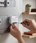 Person installing a Smart Home Energy Monitor With Real Time Circuit Tracking For Heavy Loads And Ev Chargers into an electrical panel.