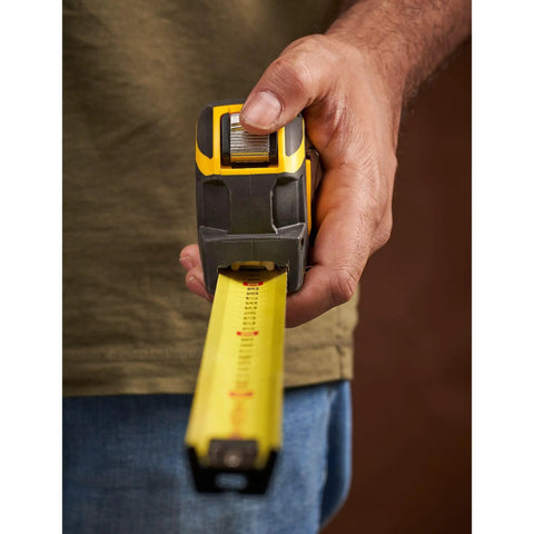 Person using Fatmax Autolock Tape Measure 8m Metric Only Yellow Black, showing reverse lock for one-handed control.