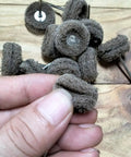 Close-up of a hand holding abrasive nylon fiber buffing pad from 48 Piece Rotary Tool Buffing Wheel Set With Three Thirty Second Inch Mandrels And 2.35 Mm Shanks, Dremel Compatible