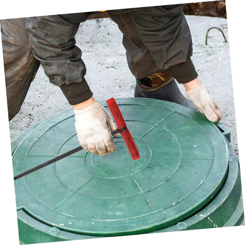 Heavy Duty Manhole Cover Lifter Hook Rock Solid Steel Build With Secure Comfort Handle and Slick T Shape Design For Quick Grate Drain Lid and Roller Shutter Access Without Any Fuss At All, being used on a green manhole cover.