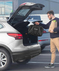 Man loading groceries in SUV trunk with portable EV charger bag