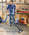 Person using Super Stretch 2.5 Inch Expandable Shop Vac Hose Kit For Quick Cleanups in a workshop setting