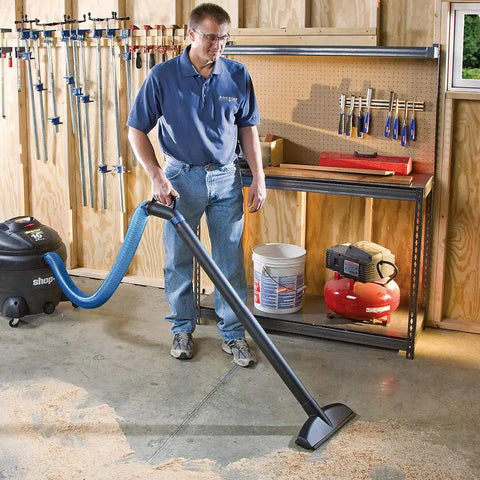 Person using Super Stretch 2.5 Inch Expandable Shop Vac Hose Kit For Quick Cleanups in a workshop setting