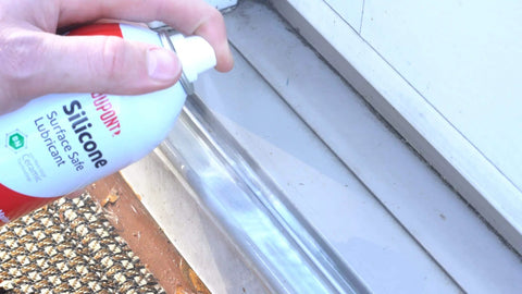 Person applying Silicone Lubricant With Teflon Fluoro Polymer For Non Metal Materials on a door track to reduce friction and sticking