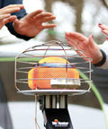 540-Degree 45,000 BTU Tank Top Radiant Propane Heater With Multi Directional Heat, showing safety cage and hands warming outdoors
