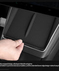 Hand touching Tesla Model Y Juniper Center Console Qi Wireless Charging Pad With Non Slip Silicone Mat in black inside car