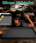 Mechanic using Under Car Oil Drip Mat, Silicone Spill Tray for Garage Floor, 34x22 Inch, no splatter surface.