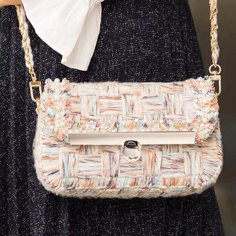 Pastel tweed handbag with gold chain strap and front metal turn-lock clasp.