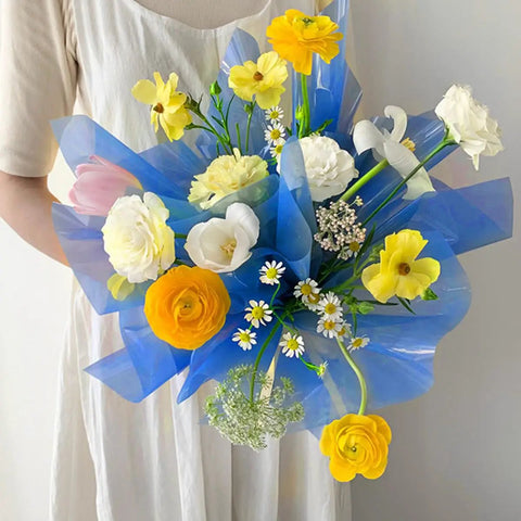 Bouquet wrapped in blue Transparent Candy Color Flower Wrapping Paper Pack 20 Sheets For Bouquets And Gift Wrap held by person