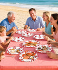 Heavy Duty 50 Pack Crab Boil Paper Plates 9 Inch Round Disposable Dinnerware used at a beach gathering with seafood.