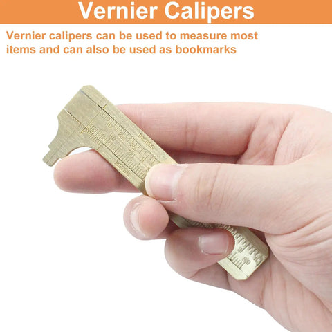 Hand holding Old School Brass Pocket Vernier Caliper Ruler With Double Scale mm And Inch Handy Sliding Gauge Measuring Tool.