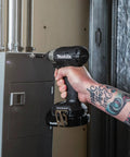 Hand using XDT18SY1B-R 18V LXT Sub Compact Brushless Impact Driver Kit to fasten screws on a metal panel