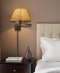 Cambridge 15 Inch Modern Sleek Swing Arm Wall Sconce with latte mocha shade above nightstand in bedroom