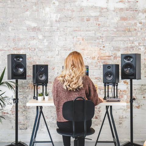 Person seated at a desk with iD14 MKII USB-C Audio Interface with 2 Class-A Mic Preamps and speakers in a studio setup.
