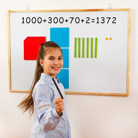 Girl using 131-Piece Jumbo Magnetic Base Ten Blocks Set for Math Place Value on a whiteboard in K-3 classroom.