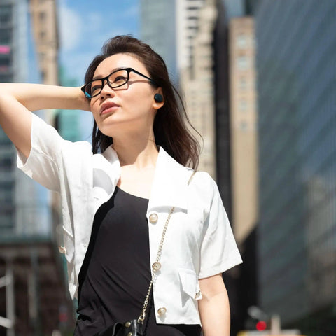 Person wearing Tune Buds True Wireless Earbuds With Noise Cancellation And Pure Bass Sound Bluetooth Five Point Three in urban setting.