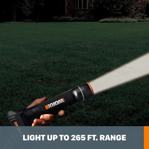 Person holding 20V Power Share Multi Function LED Flashlight with 265 ft beam illuminating a lawn at night