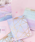 Colorful Marble Pattern Gift Bags With Tissue Paper And Gold Foil Accents, Medium Size 7x4x9 Inches, 4 Pack displayed on table