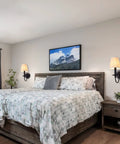 Bedroom with Black Wall Sconces Set Of Two With Linen Fabric Lampshades above bed, creating cozy ambient lighting.