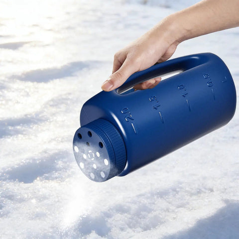 Person using handheld seed shaker and spreader with 90 oz capacity, blue, on snow for ice melt application.