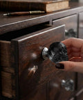 Sick Badass Crystal Skull Drawer Knobs Four Pack Heavy Duty Glass Cabinet Pulls Handle Gray Gothic Statement Piece For Dresser And Halloween Decor close-up, mounted on a wooden dresser.
