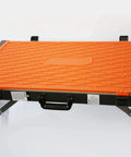 Close-up of an orange Four In One Portable Folding Workbench And Scaffold Platform with handle and metal frame, showing texture details.