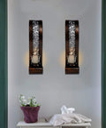 Upgrade Your Vibe With These Badass Antique Bronze Wall Sconces Featuring Openwork Glass Shade Tealight Holders on a wall with candles.