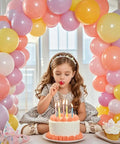 Balloon arch stand with base; pastel pink, purple, yellow balloons form a birthday backdrop behind a girl at a cake.