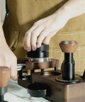 User preparing coffee tools on Smooth Operator Wood Espresso Tamper Station Fits 51 And 58 Mm Baskets Non Slip Base.