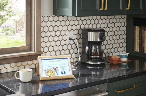 Kitchen countertop with 15A GFCI USB In Wall Charger Outlet With Dual USB Ports, tablet charging, coffee maker, and backsplash in view.