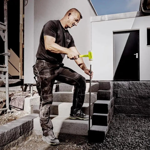 Worker using Hi Viz Dead Blow Mallet With Non Rebound Action on construction site, focusing on precise, controlled strikes.