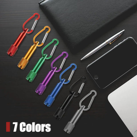 25 Pack Mini Keychain LED Flashlights With Carabiner For Outdoor Summer Use, shown in 7 colors with a pen and phone nearby.