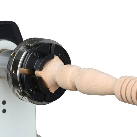 4-jaw self-centering wood lathe chuck in black metal gripping a turned wooden spindle
