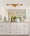 Gold Bathroom Vanity Light 28 Inch Four Light Fixture With Clear Glass Globes, Hand Painted Gold Finish in bright bathroom space