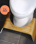 Contempo Slim Teak Finish Toilet Stool, 7 Inch Height, Brown And White, placed around a standard toilet on a tiled floor
