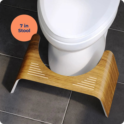 Contempo Slim Teak Finish Toilet Stool, 7 Inch Height, Brown And White, placed around a standard toilet on a tiled floor