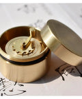 Top Shelf Vintage Brass Mini Tape Measure With Retractable Sewing Ruler That Is Totally Built Tough For All Tailor Jobs Featuring One Meter Gauges You Gonna Adore Using On Every Next Crafting Project Today Right Now, open brass casing showing winding mechanism.